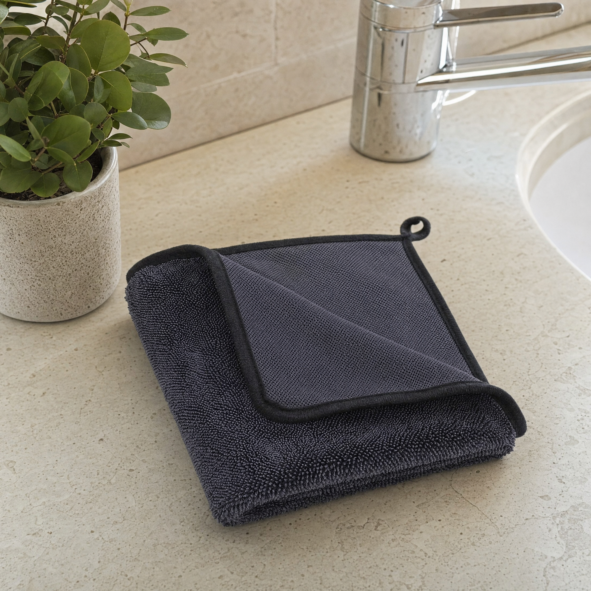 Folded charcoal Microfibre Cleaning Cloth on a stone benchtop showing both textures